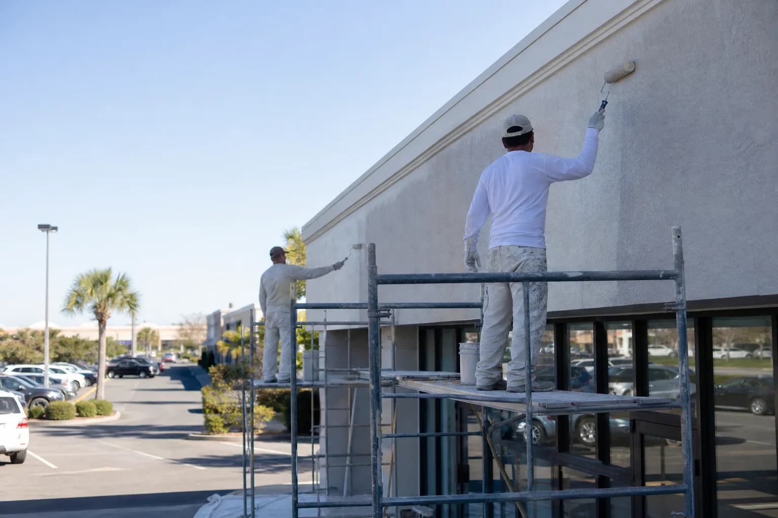 Commercial painters refinishing a retail storefront facade in Spanish Fort, AL near the Eastern Shore Centre