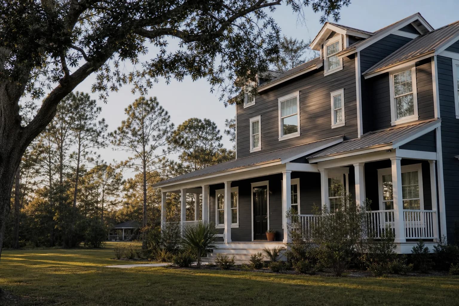 Dark charcoal exterior on a heat-stable fiber cement Gulf Coast home with white trim in afternoon sun