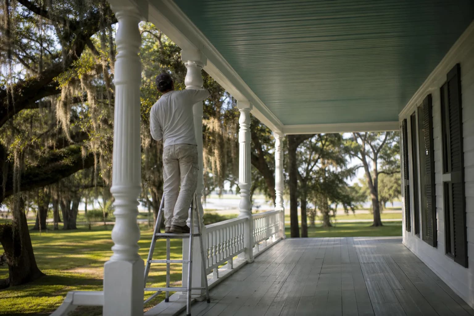 Painting the column and tongue-and-groove ceiling of an older deep front porch on a Mobile, Alabama home