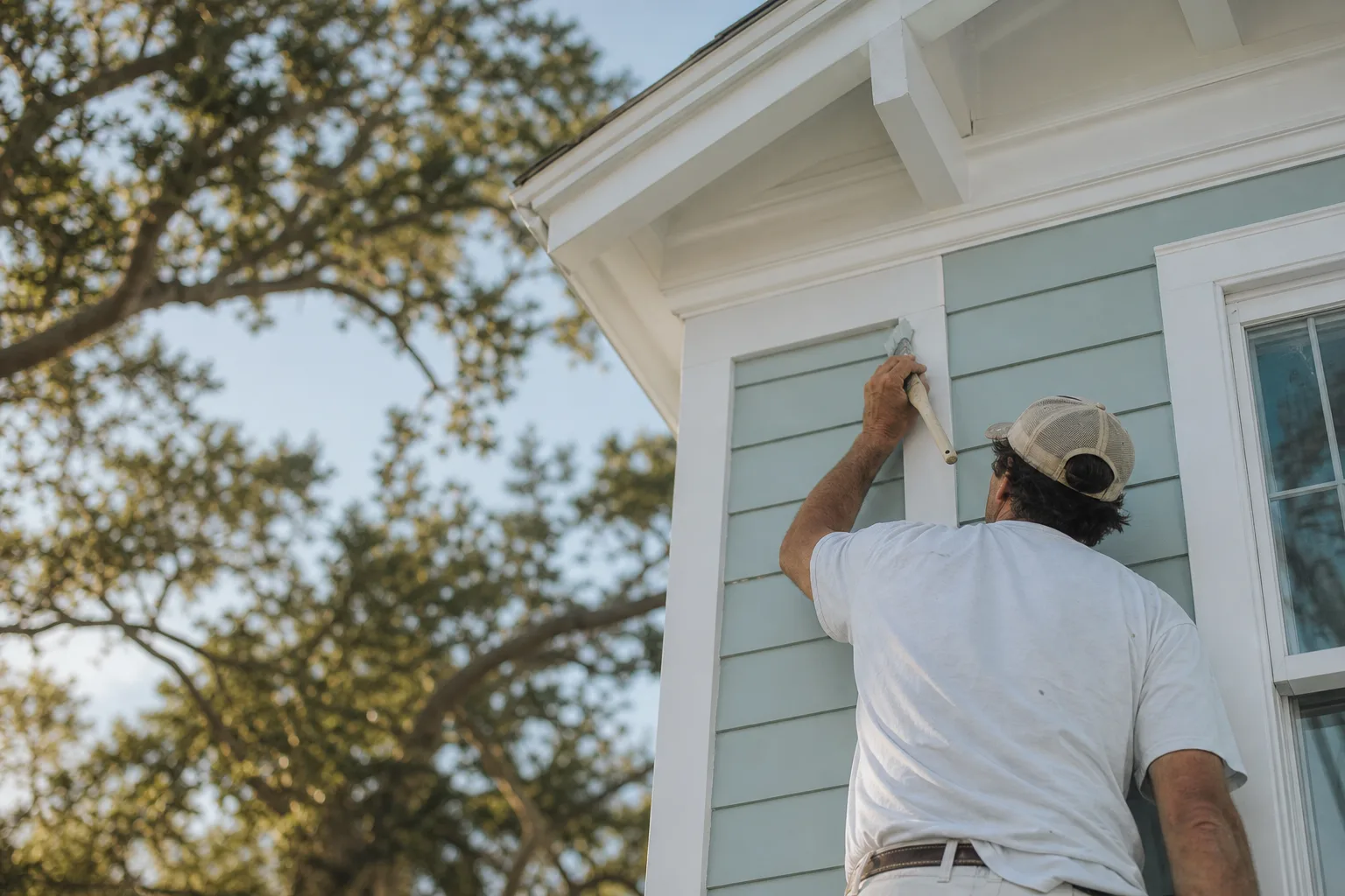 Crisp white exterior trim framing pale siding on a coastal home, illustrating exterior trim color ideas