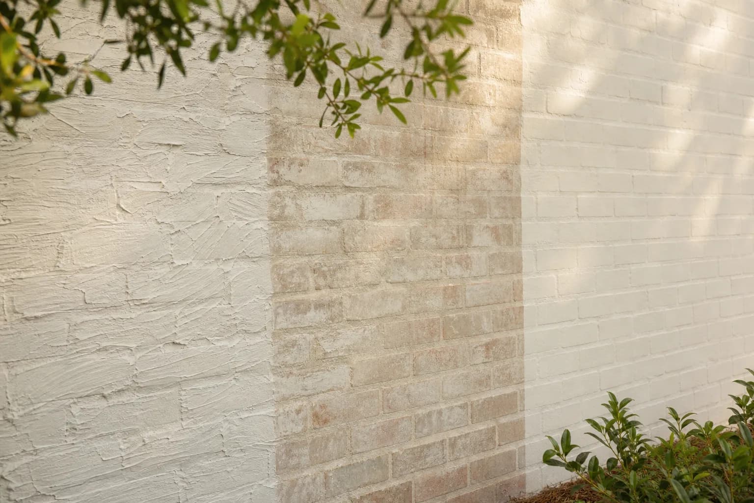Brick wall comparing German smear, limewash, and painted brick finishes side by side