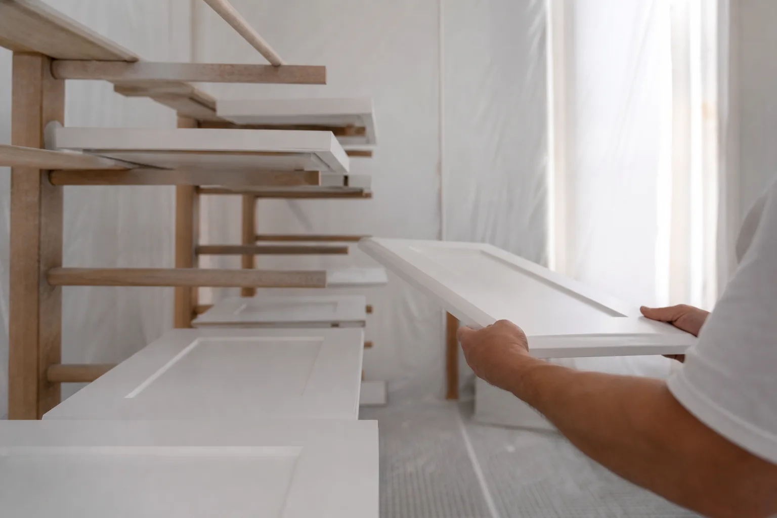 Freshly painted kitchen cabinet doors curing in Pro 1's off-site drying booth, illustrating the cost to paint kitchen cabinets in 2026