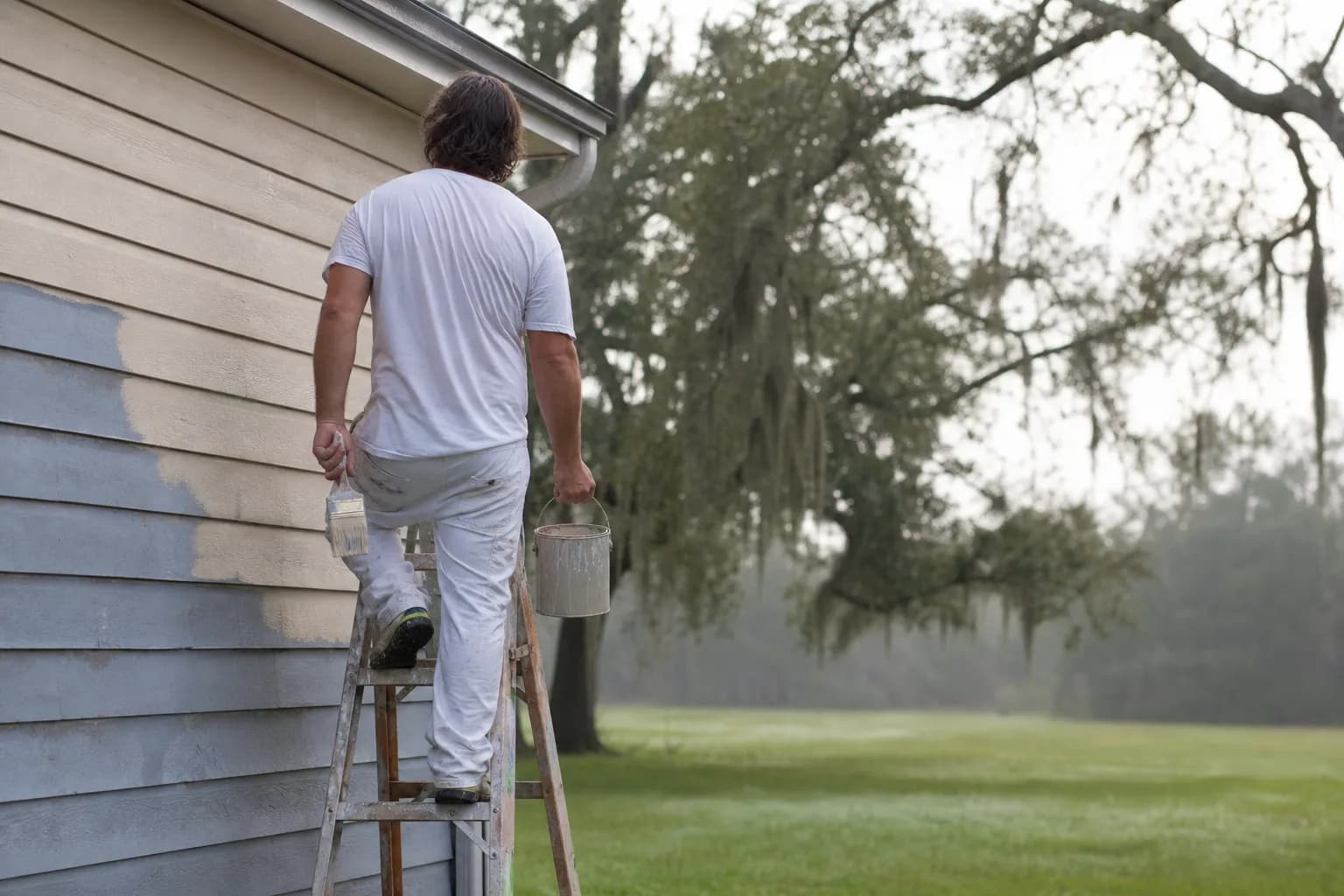 Painter checking conditions on a humid Gulf Coast morning before exterior painting, on dew point and humidity