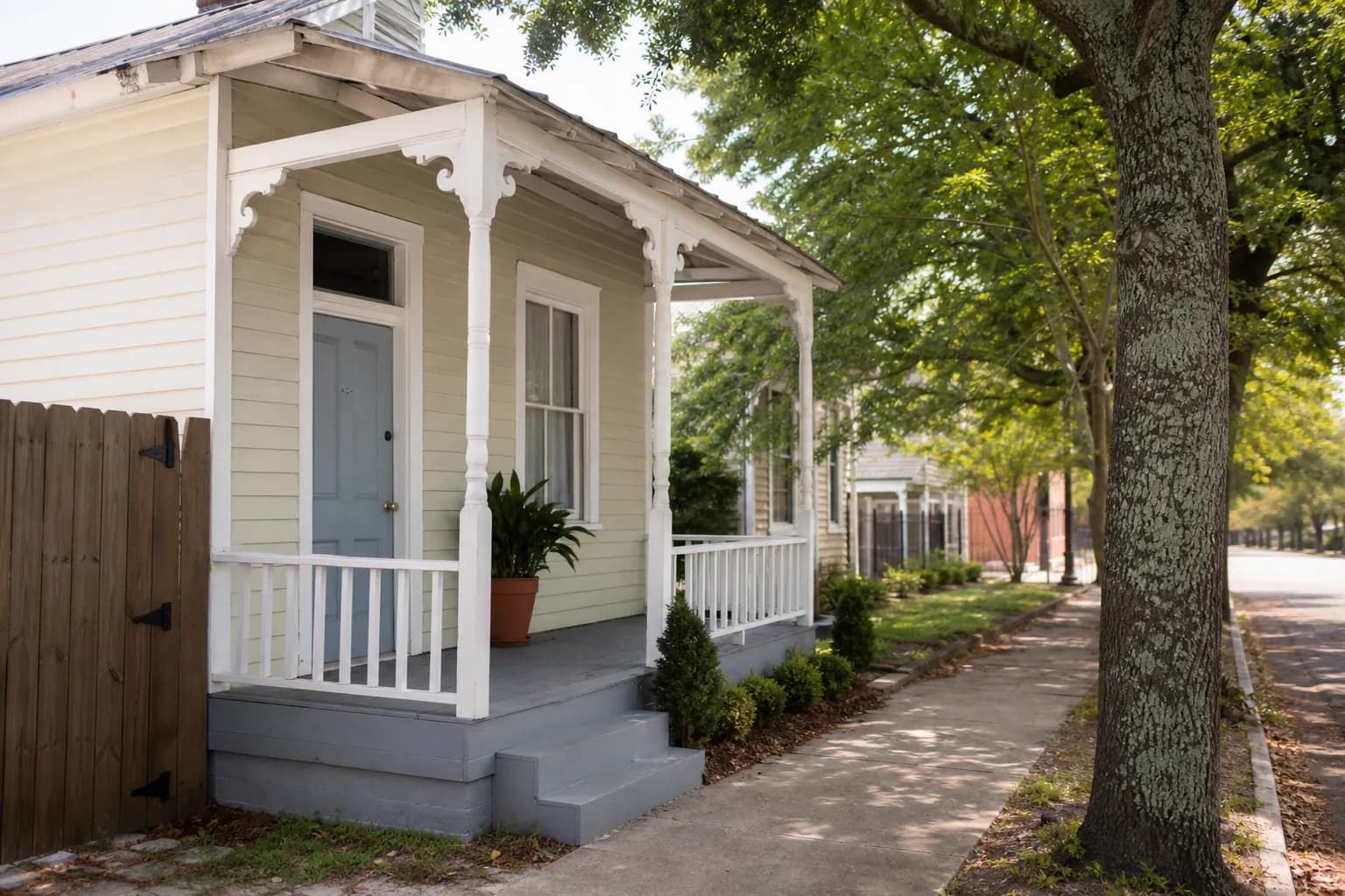 Restored narrow shotgun house with a small front porch in a historic Mobile neighborhood